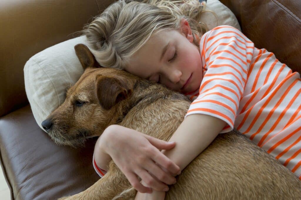 Child sleeping with dog