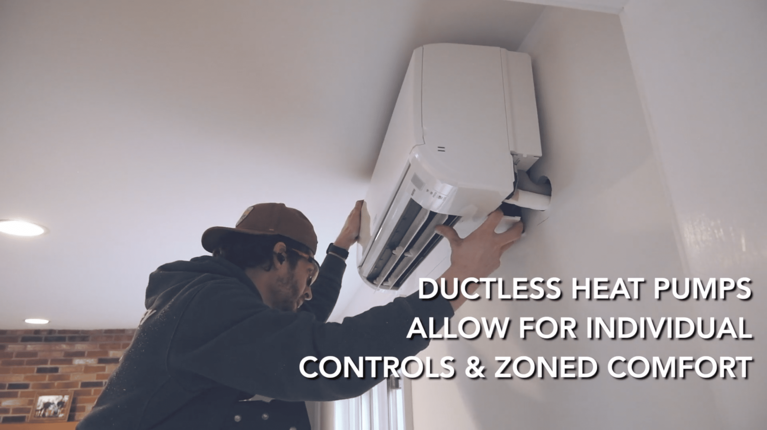 man working on a heat pump wall unit