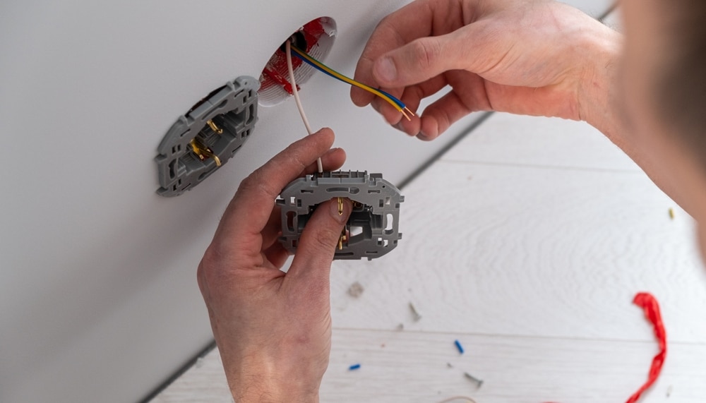 Technician installing electrical outlet