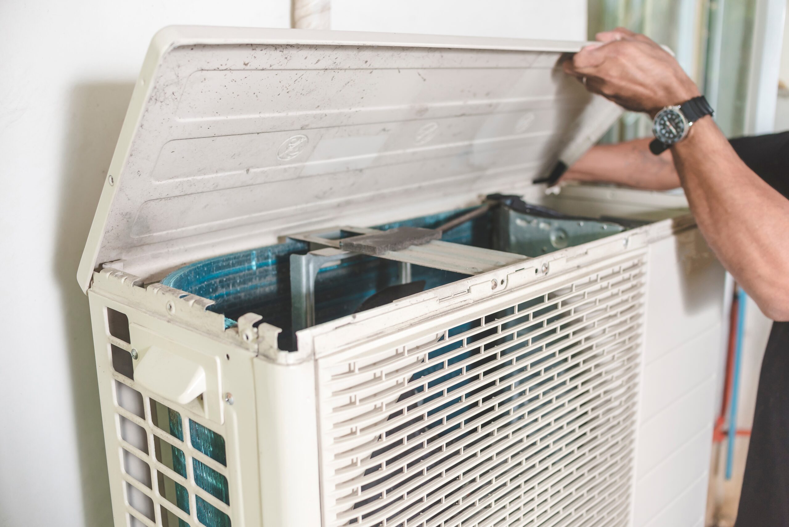 person repairing a heat pump outdoor unit