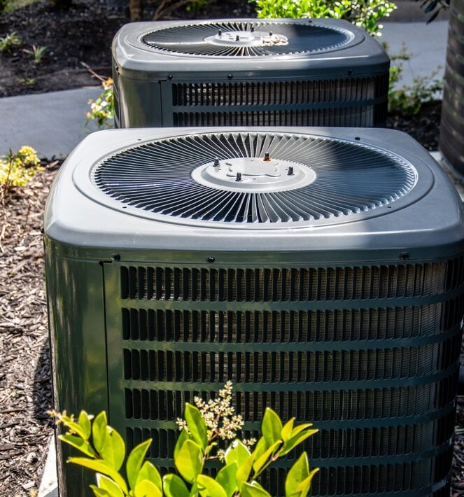 Close,Up,Residential,Air,Conditioner,Units,Outdoor,Red,Brick,Bushes Heat Pumps outside of house