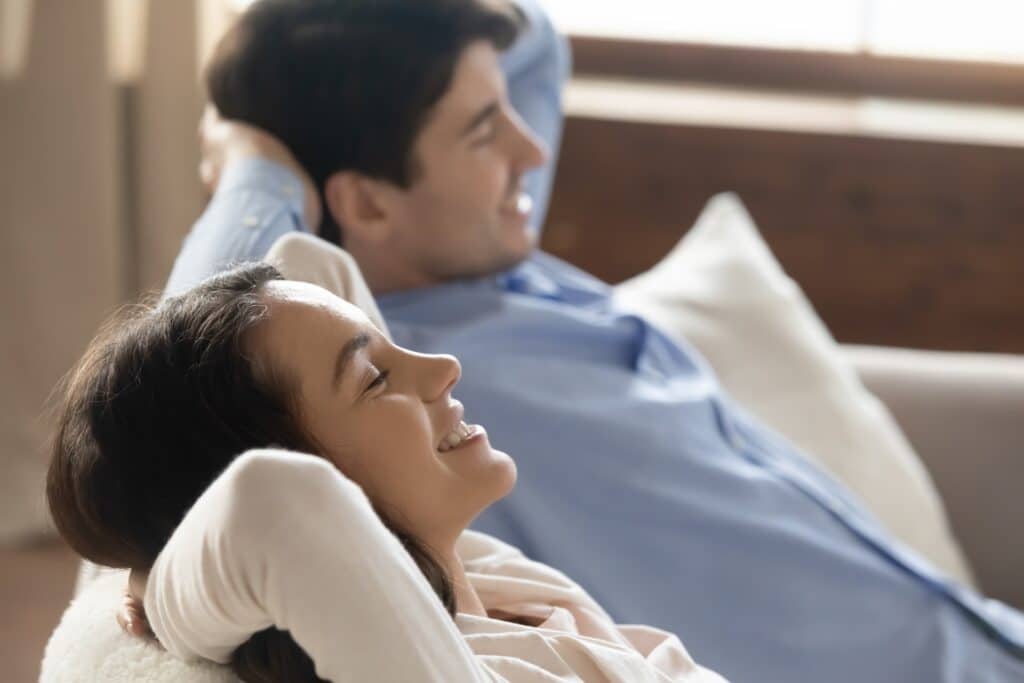 couple sitting on could breathing in the fresh air in their home